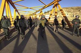 Riot police guard a bridge in Ilave, 565 miles (910 kilometers) southeast of Lima, Peru, on Tuesday, May 11, 2004. T The government said it was prepared to declare a state of emergency if violence breaks out at the protest by Aymara Indians demanding the release of six people arrested for last month's killing of a provincial mayor. During three weeks of protests leading up to the lynching, demonstrators blocked this bridge, choking off the highway leading to Bolivia. (AP Photo/Martin Mejia)