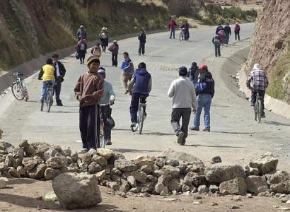 A boy stands over the blocked entrance of the international bridge scattered with rocks in Ilave, 565 miles (910 kilometers) southeast of Lima, Peru, on Tuesday, May 25, 2004. Hundreds of soldiers and riot police have entered Ilave in recent days to end clashes between protesters and police.  Protesters in the town of Ilave, near Lake Titicaca, are demanding the release of a leader imprisoned on suspicion of inciting a mob that killed the mayor there on April 26. (AP Photo/Martin Mejia)
