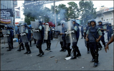 Bangladeshi riot police us tear-gas to disperse angry crowds following a blast outside the main opposition party the Awami League's office in Dhaka. At least nine people were killed and as many as 80 injured when several blasts ripped through a Bangladeshi opposition party rally.(AFP/Farjana K. Godhuly)